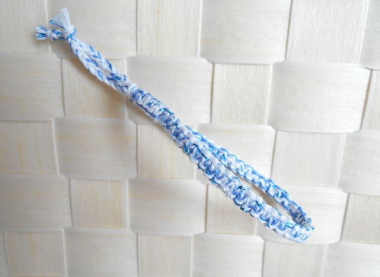 Bracelet en macramé plat 4 fils, coloris blanc et bleuet, aspect satiné, relevé d’un fil lurex très fin bleu métallisé