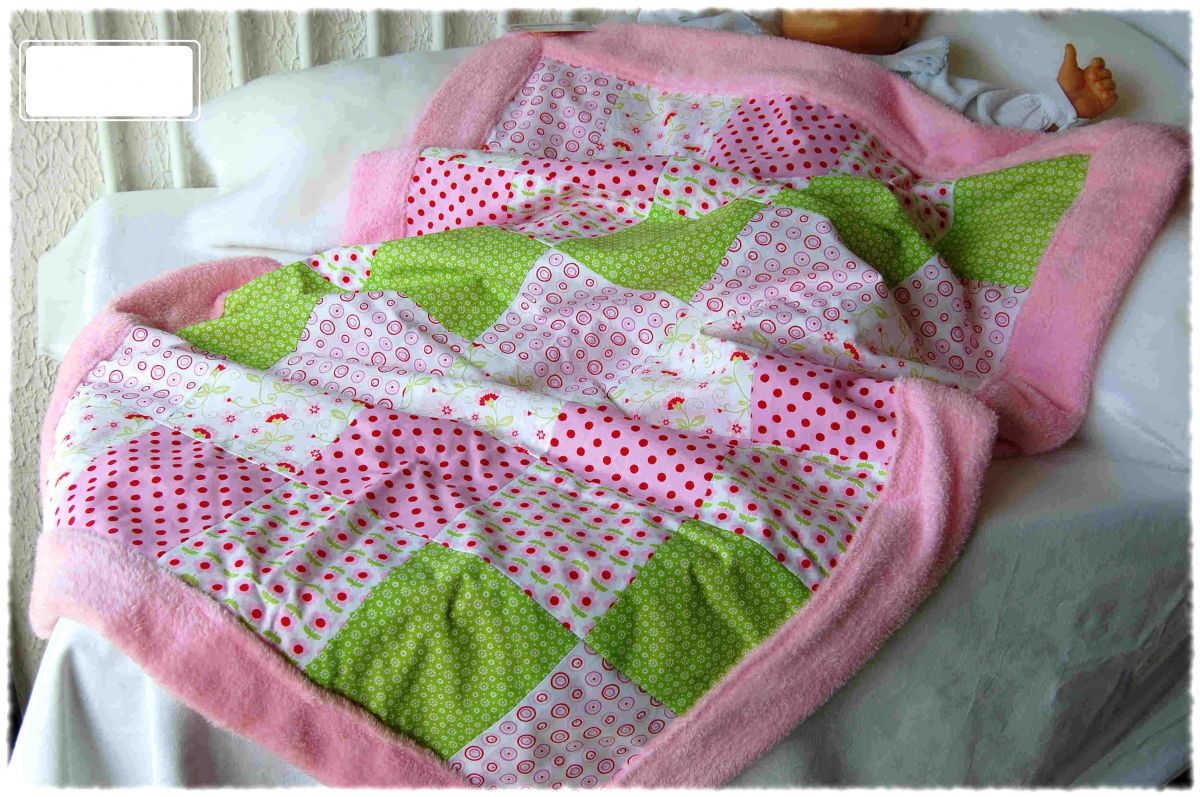 Couverture de bébé en polaire rose et patchwork de coton vert, rose, rouge.