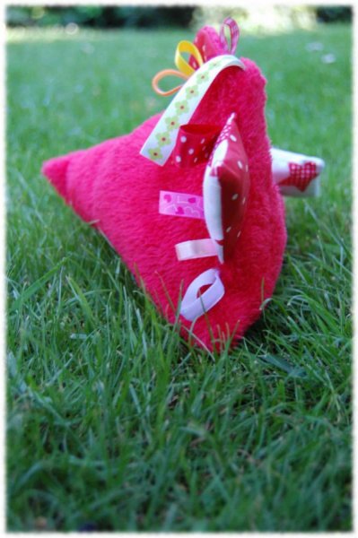 Doudou bébé forme de berlingot, en polaire rouge avec des pièces de tissus et des rubans