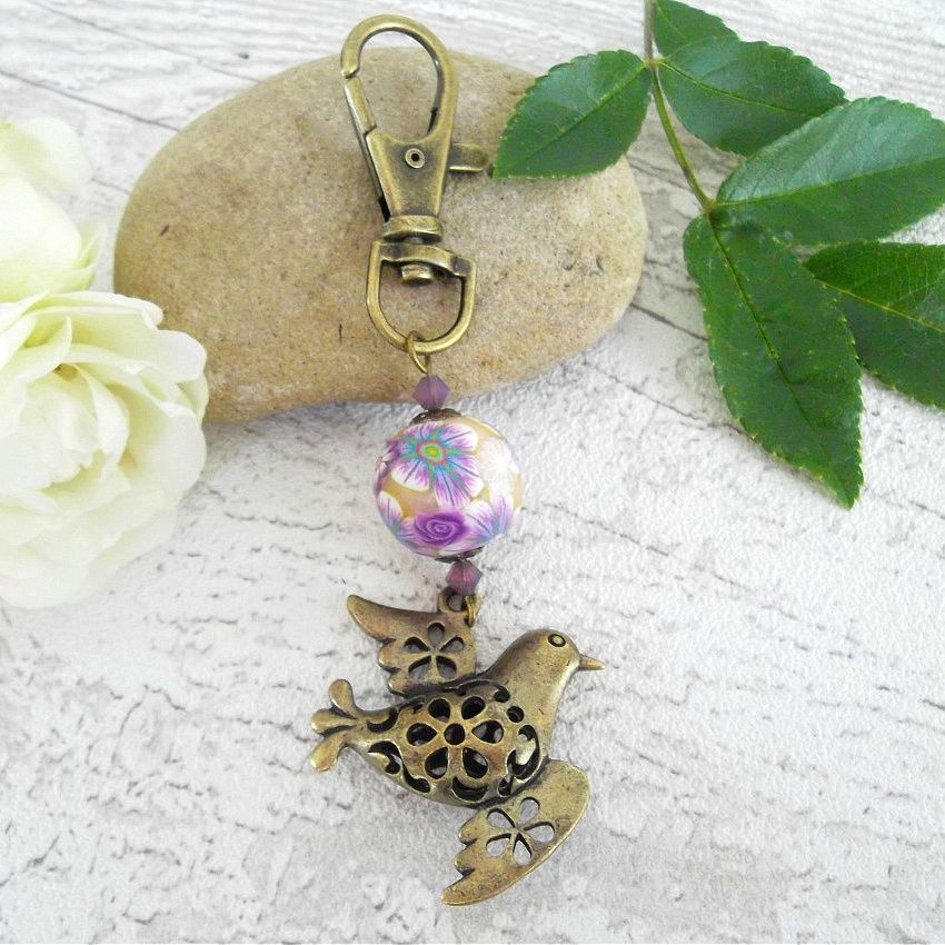 porte clé pedentif colombe de la paix couleur bronze et perle fleuri jaune et violet