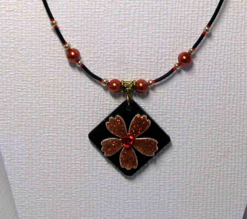 collier pendentif fleur cuivrée sur cordon silicone