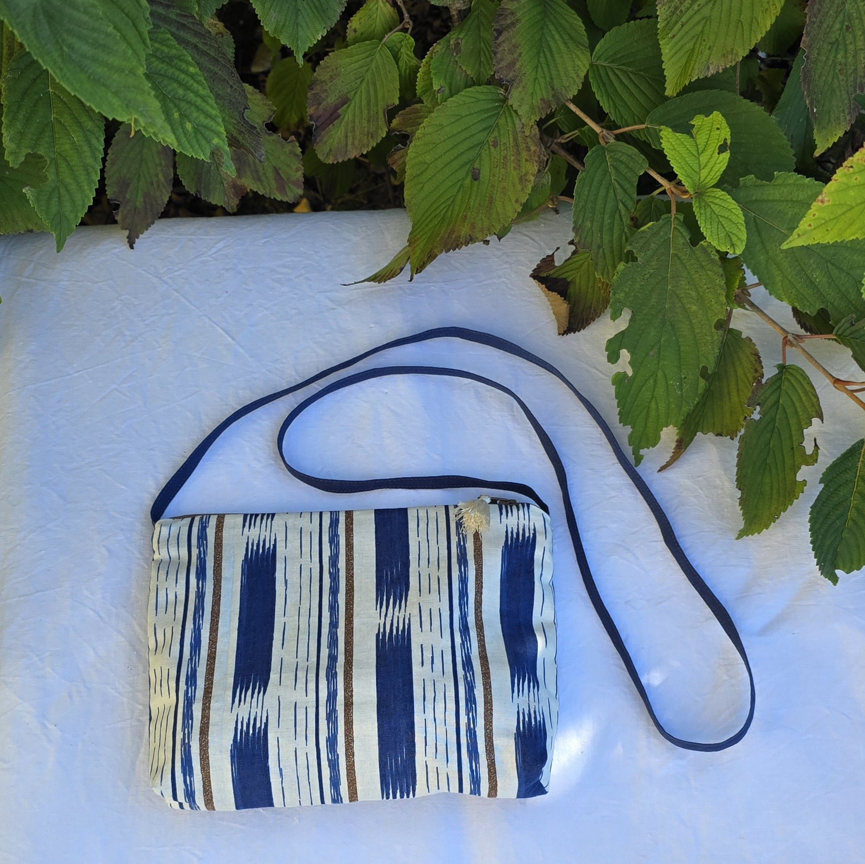 Pochette avec bandoulière en tissu coton bleu et marron agrémentée d'un pompon