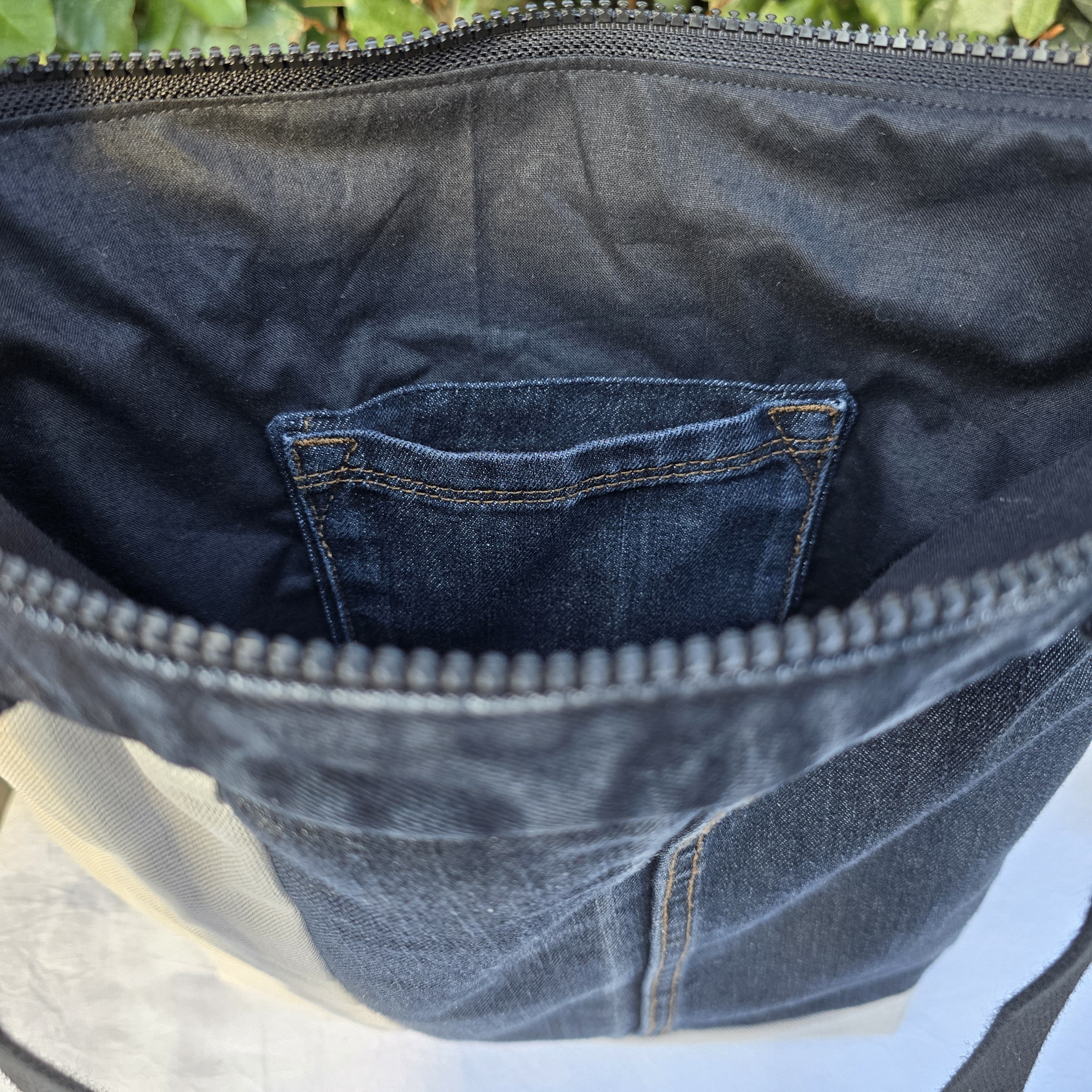 Sac à bandoulière en jean recyclé noir et gris avec empiècements.