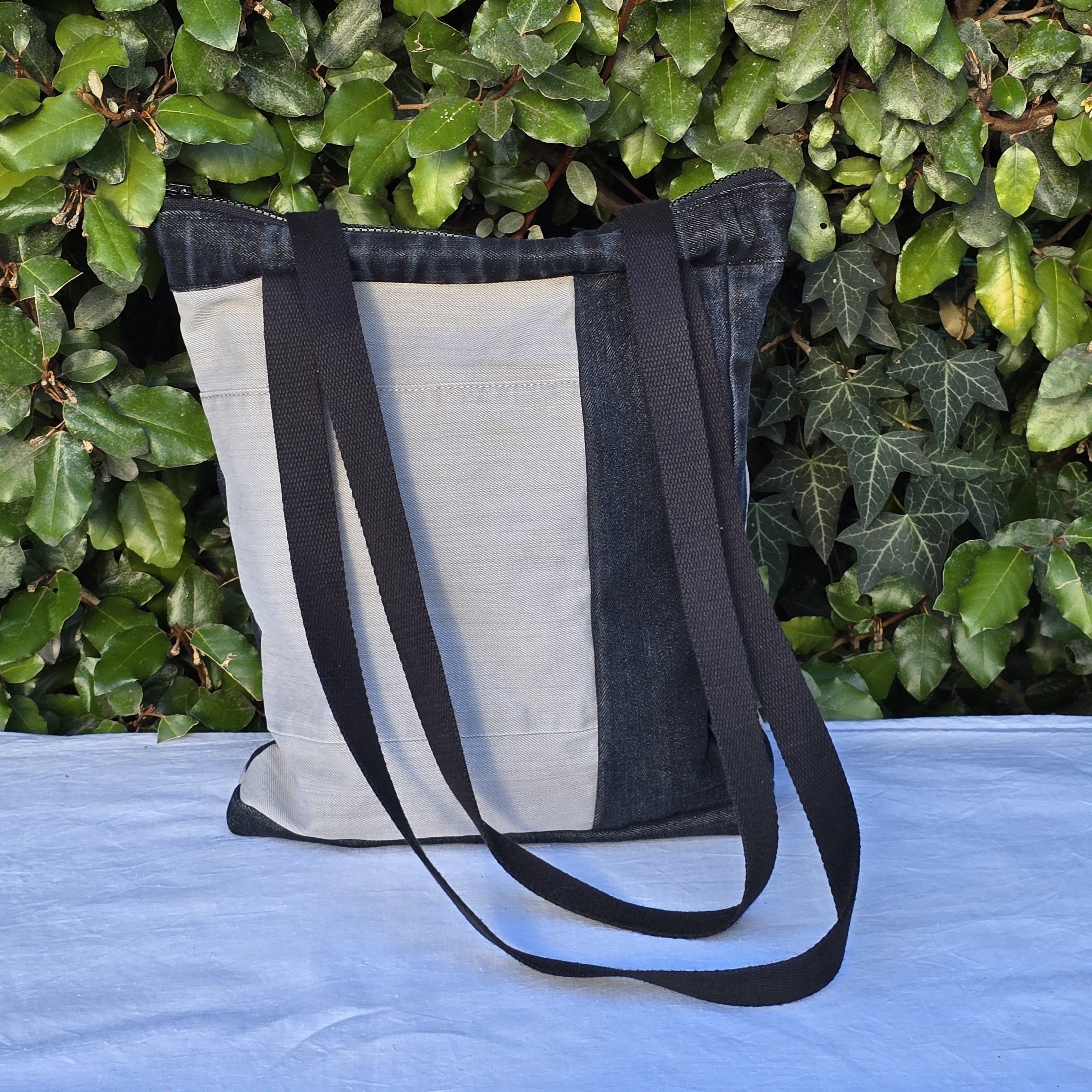 Sac à bandoulière en jean recyclé noir et gris avec empiècements.