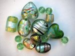 Lot de 12 perles en verre différentes, tons vert foncé avec reflets or