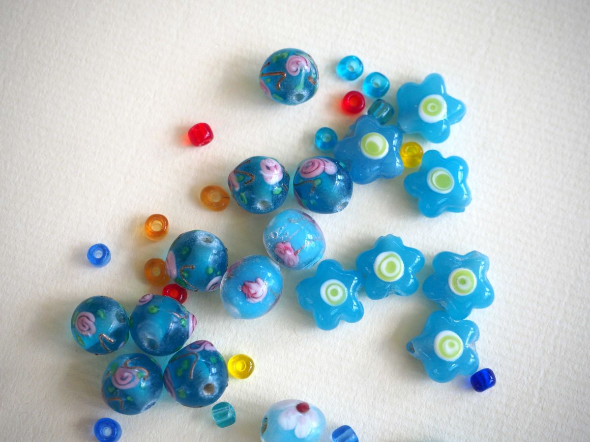 Lot de 20 perles en verre différentes  tons turquoise avec fleurs, argent et motifs