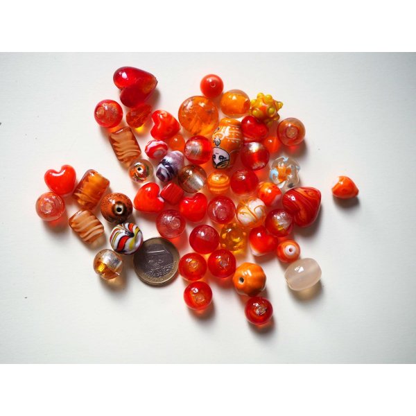 Lot d' une cinquantaine de perles env tons orangés/rouges de différentes formes 