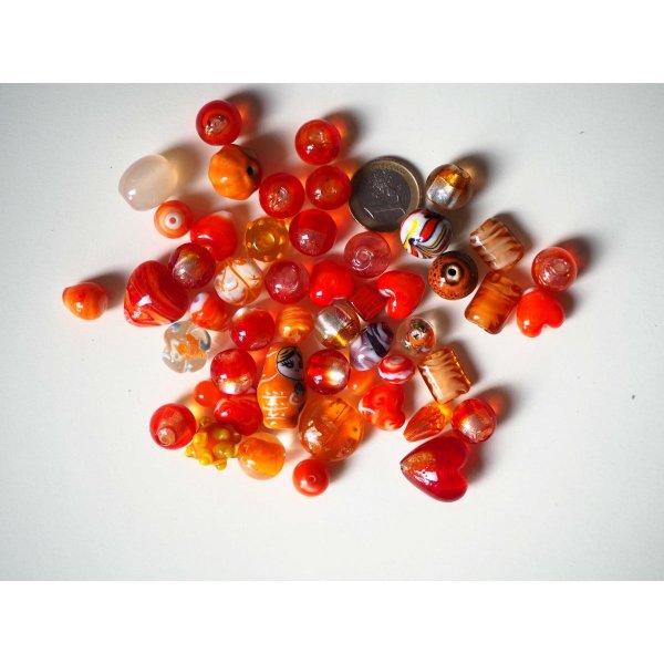 Lot d' une cinquantaine de perles env tons orangés/rouges de différentes formes 