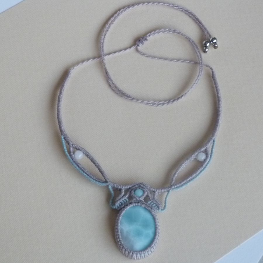 Collier en micro-macramé gris taupe/bleu givré avec en pièce centrale une pierre gemme naturelle aux douces nuances de blanc et de bleu clair.