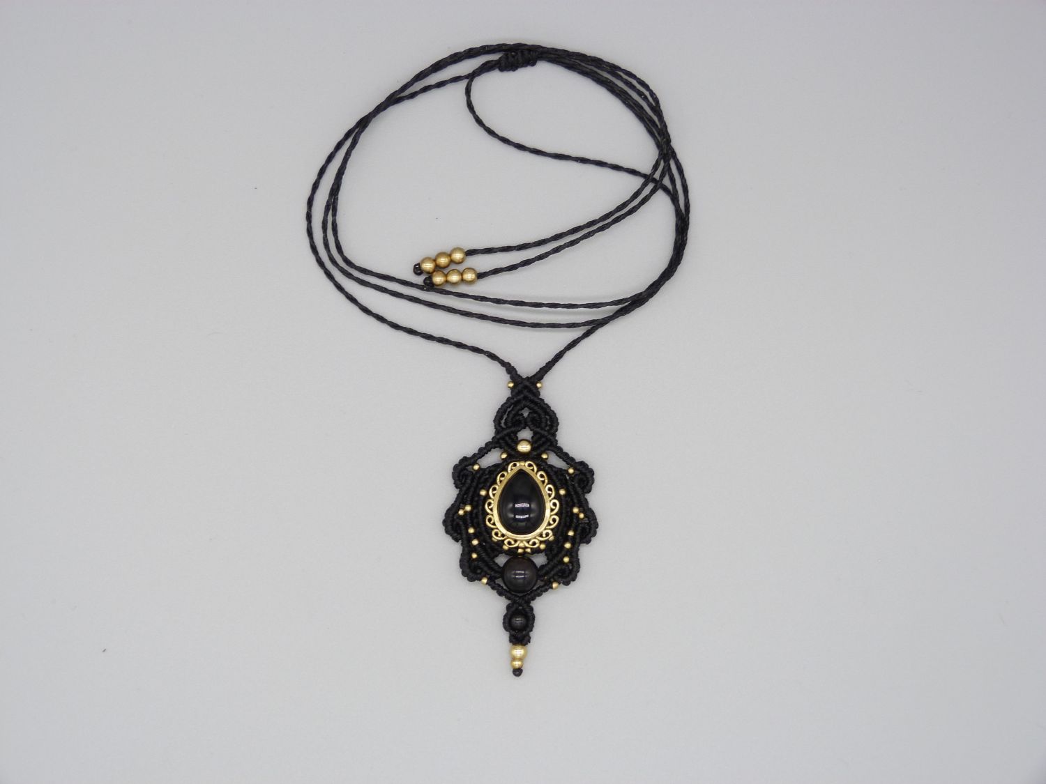 collier noir en micro-macramé avec une obsidienne sertie de métal doré