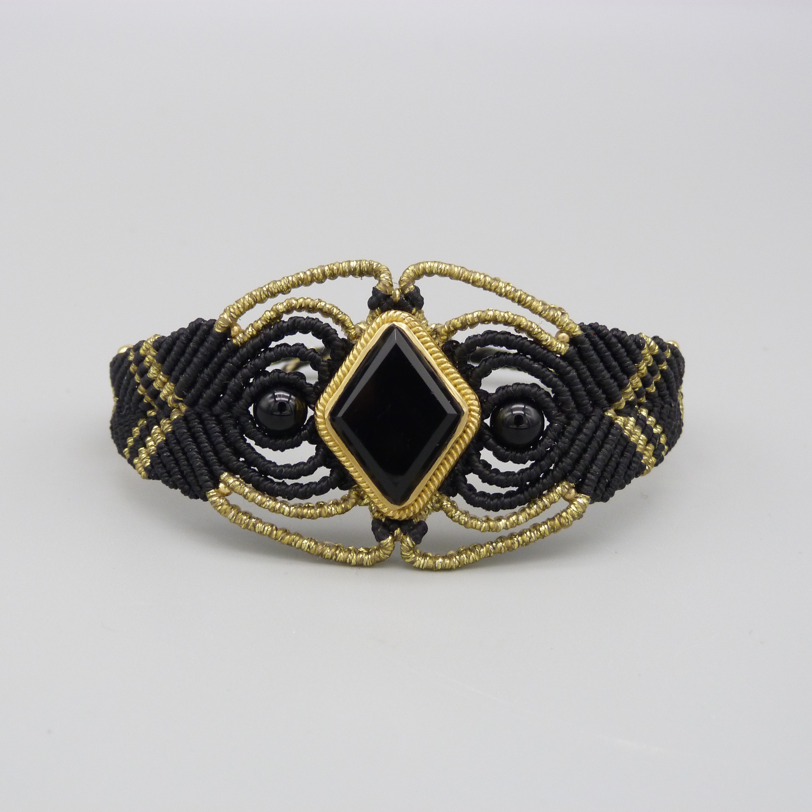 Manchette noire en micro-macramé avec une pierre onyx noire sertie de laiton