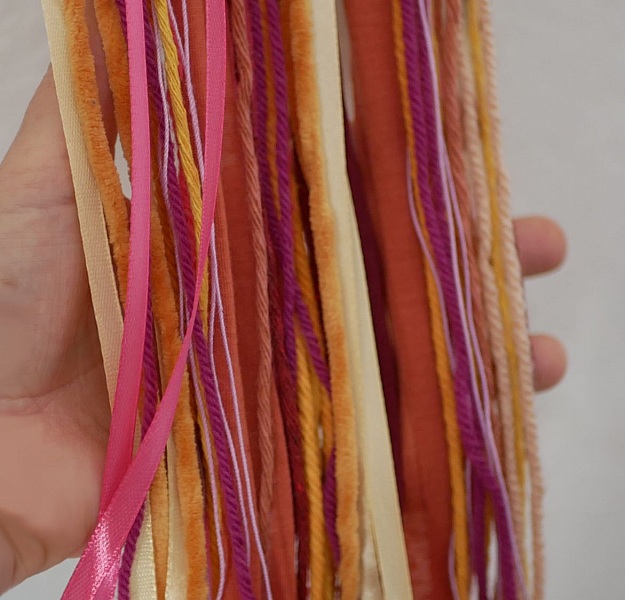 Suspension tissage mural aux laines de couleurs vives et longues franges