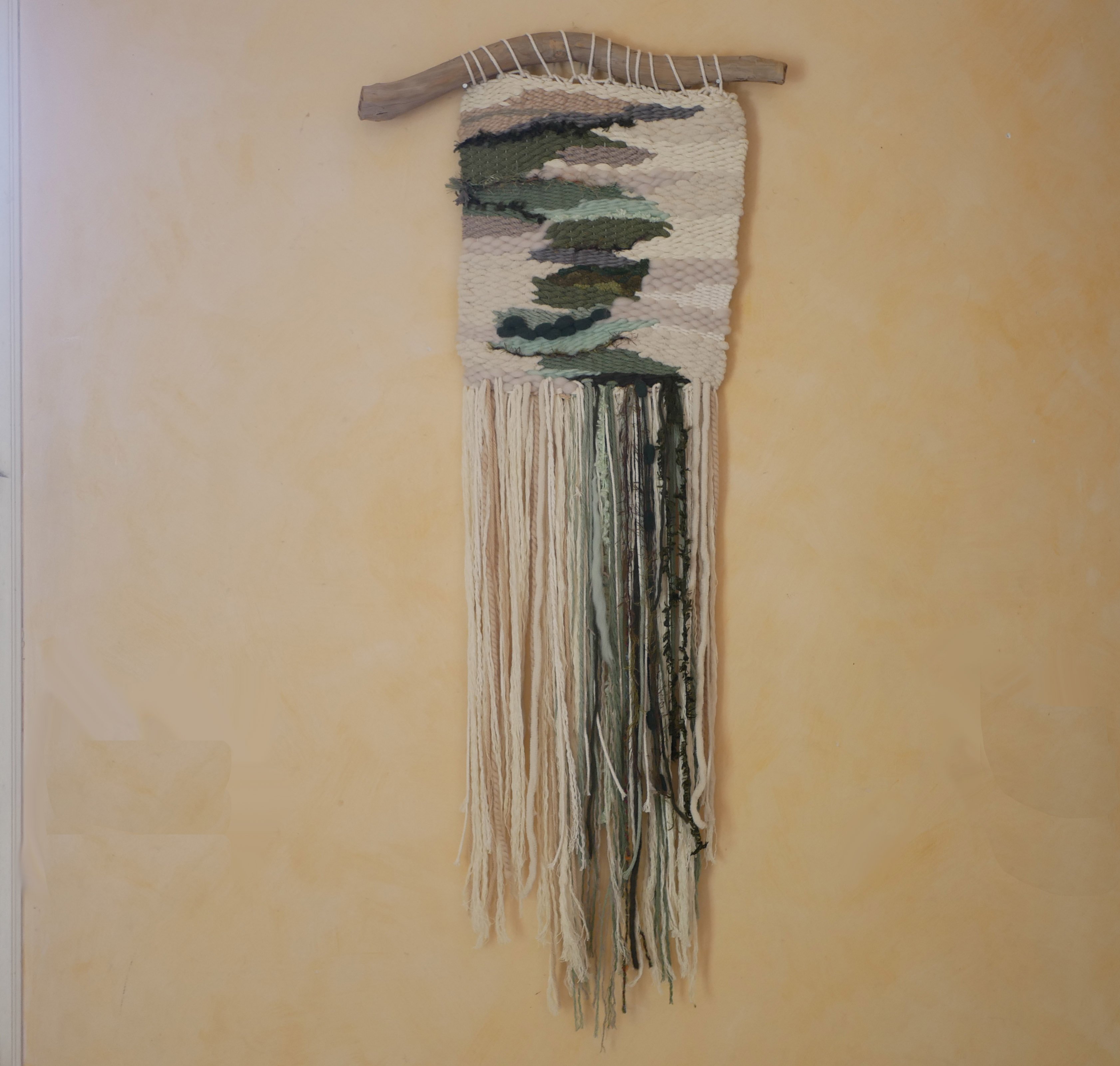 Suspension tissage mural "Les rivi&egrave;res v&eacute;g&eacute;tales" en laines et coton de couleurs vert d'eau et longues franges