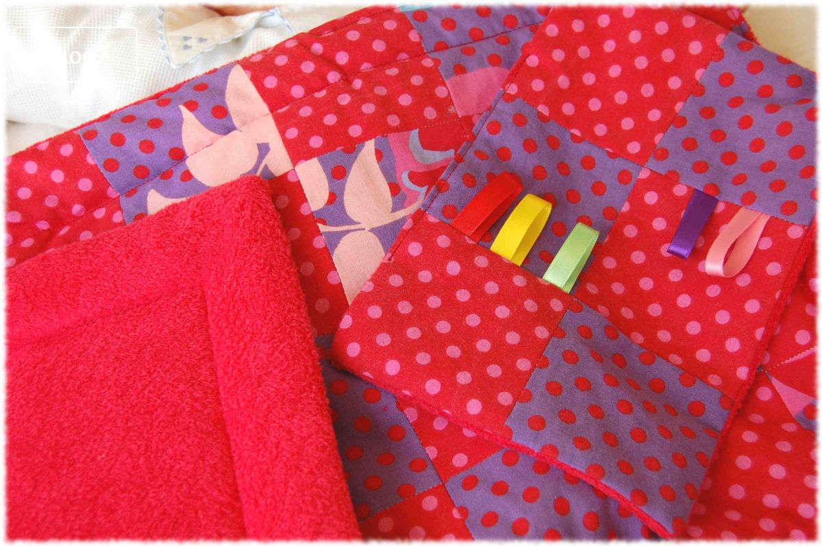 Couverture berceau bébé en coton patchwork et velours à dominante rouge, doublée de ouate