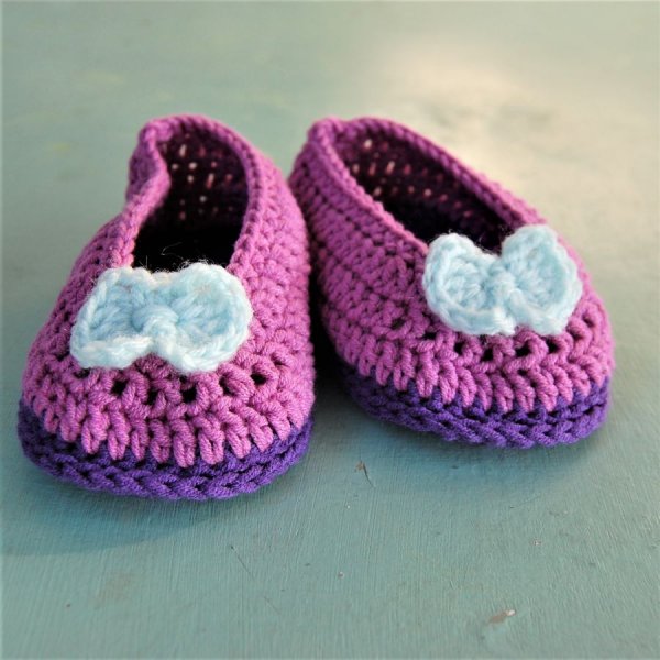 Paire de chaussons roses et violets avec un noeud vert d'eau