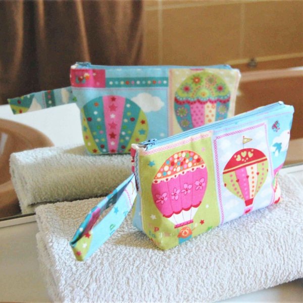 Trousse de toilette en coton turquoise rose motif montgolfières et intérieur beige, zip bleu ciel