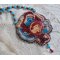 Collier Bel’Art brodé sur une base en suédine Bordeaux un cabochon baroque d’une femme des années 1950 en Résine à laquelle s’ajoute : perles rondes nacrées, chips Grenat, fleurs Lucites et rocailles 