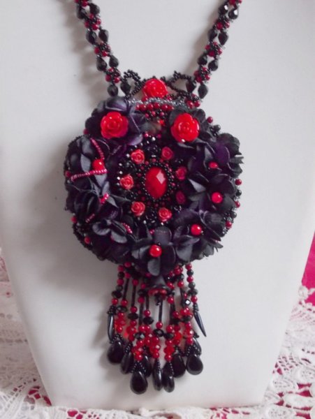 Collier Midnight in Paris brodé avec cabochon ovale facetté, cabochon rond en cristal, perles magiques, dagues, perles nacrées, ruban de fleurs. Le tout est dans les tons de Rouge, Noir et gris