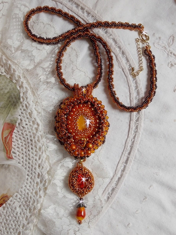 Collier pendentif Lady in Orange est brodé avec des cristaux de Swarovski, des rocailles Miyuki et des perles.magiques