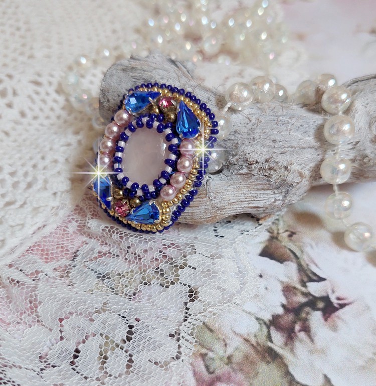 Bague Gabrielle brodée avec un cabochon ovale en pierre de gemme : le Quartz Rose à laquelle s'ajoute des cabochons poires et chatons en Cristal, perles nacrées, rocailles sur bague en laiton Bronze