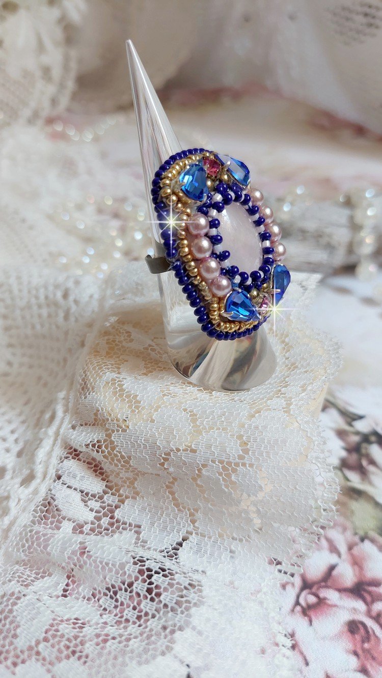 Bague Gabrielle brodée avec un cabochon ovale en pierre de gemme : le Quartz Rose à laquelle s'ajoute des cabochons poires et chatons en Cristal, perles nacrées, rocailles sur bague en laiton Bronze