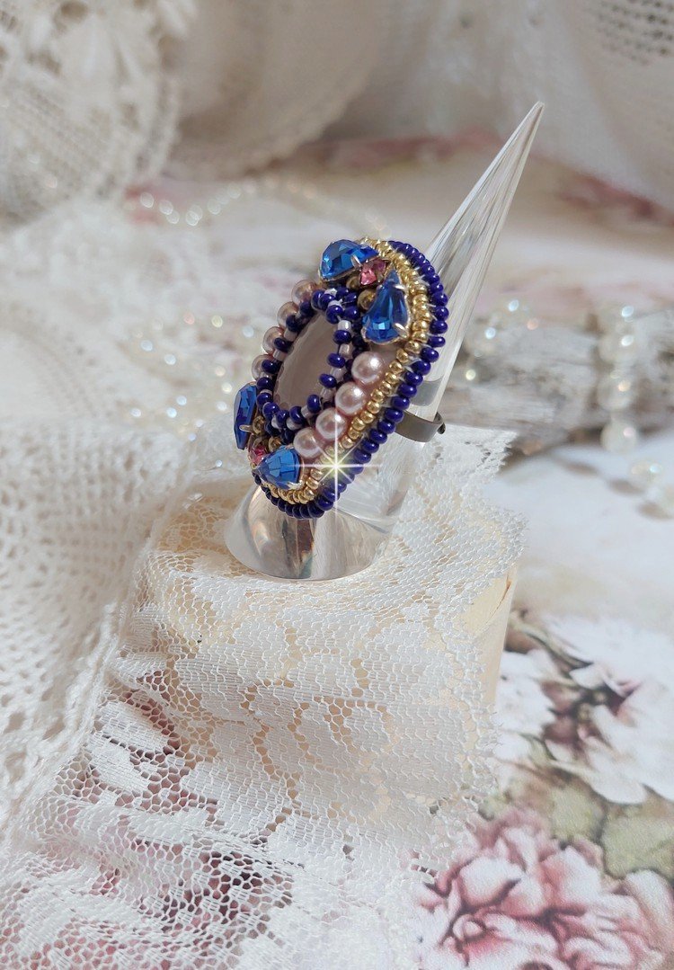 Bague Gabrielle brodée avec un cabochon ovale en pierre de gemme : le Quartz Rose à laquelle s'ajoute des cabochons poires et chatons en Cristal, perles nacrées, rocailles sur bague en laiton Bronze