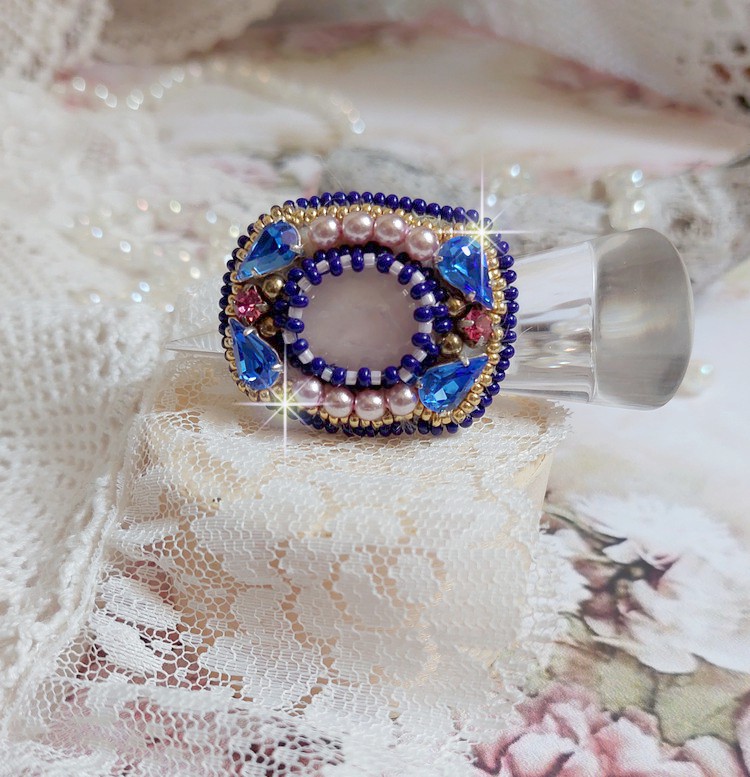 Bague Gabrielle brodée avec un cabochon ovale en pierre de gemme : le Quartz Rose à laquelle s'ajoute des cabochons poires et chatons en Cristal, perles nacrées, rocailles sur bague en laiton Bronze