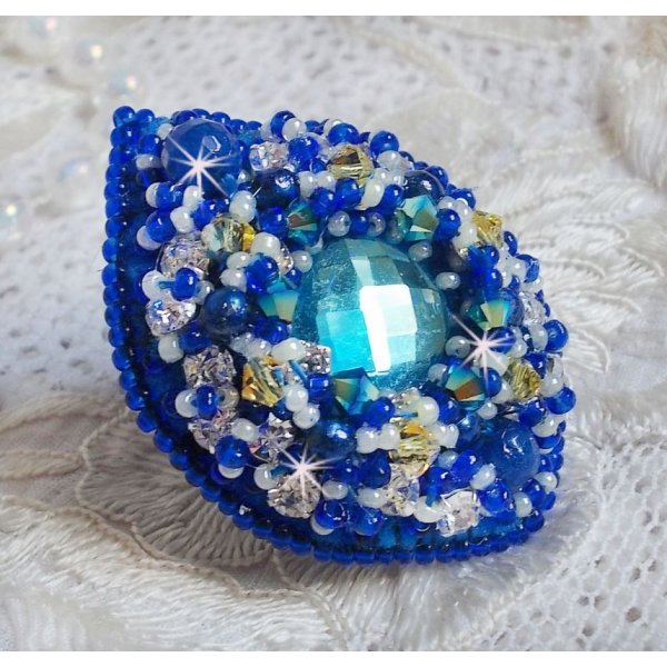 Bague Blue Palace brod&eacute;e avec un cabochon rond facett&eacute; Turquoise, des perles rondes nacr&eacute;es, estampe filigran&eacute;e, chatons, toupies en Cristal, rocailles et perles sur une bague filigran&eacute;e Argent&eacute;e