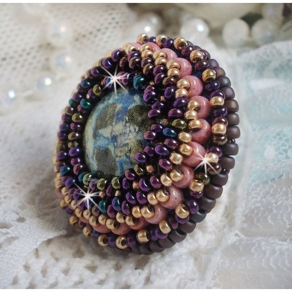 Bague Bonjour Paris cabochon marbr&eacute; bleu/vert/&eacute;cru orn&eacute;e de rocailles Miyuki dont la couleur dominante est le Violet. Mont&eacute;s sur bague dor&eacute;e en laiton et sur une feutrine Bleu n&eacute;on. Un look city !
