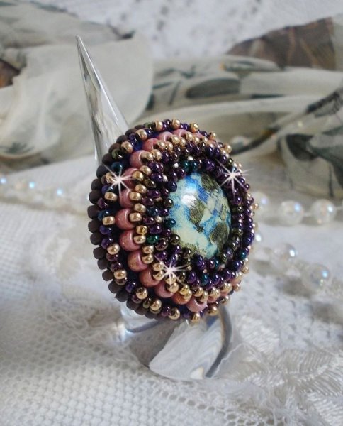 Bague Bonjour Paris cabochon marbr&eacute; bleu/vert/&eacute;cru orn&eacute;e de rocailles Miyuki dont la couleur dominante est le Violet. Mont&eacute;s sur bague dor&eacute;e en laiton et sur une feutrine Bleu n&eacute;on. Un look city !