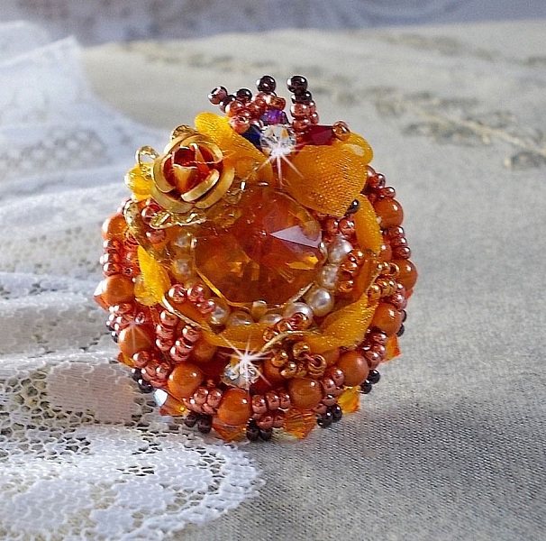 Bague Les R&ecirc;ves d'Acapulco brod&eacute;e avec un cabochon octogonale serti &agrave; laquelle s'ajoute perles rondes nacr&eacute;es, ruban organza, toupies et rocailles sur bague en laiton Bronze pour un style ethnique