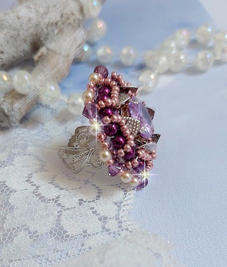 Bague Chinese Purple Stone brodée avec un cabochon rond en cristal Violet à laquelle s'ajoute une grande coupelle filigranée, facettes, perles rondes nacrées et rocailles sur un support bague Argentée