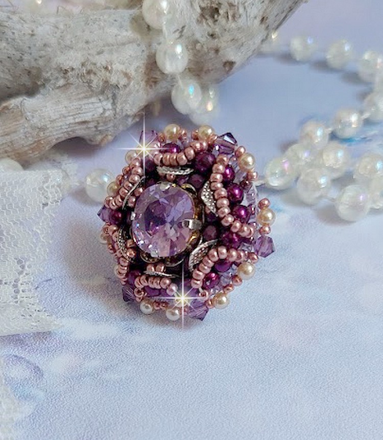 Bague Chinese Purple Stone brodée avec un cabochon rond en cristal Violet à laquelle s'ajoute une grande coupelle filigranée, facettes, perles rondes nacrées et rocailles sur un support bague Argentée