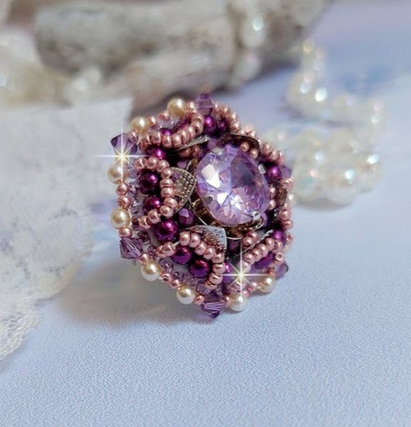 Bague Chinese Purple Stone brodée avec un cabochon rond en cristal Violet à laquelle s'ajoute une grande coupelle filigranée, facettes, perles rondes nacrées et rocailles sur un support bague Argentée