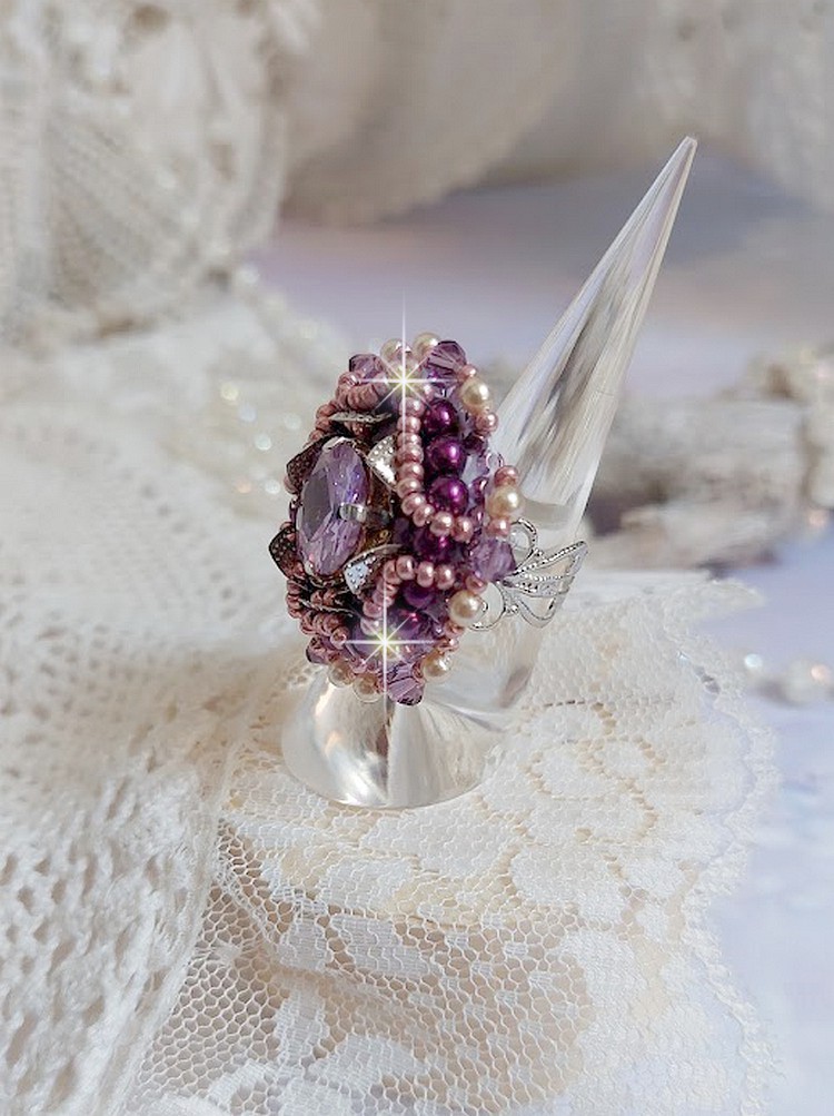 Bague Chinese Purple Stone brodée avec un cabochon rond en cristal Violet à laquelle s'ajoute une grande coupelle filigranée, facettes, perles rondes nacrées et rocailles sur un support bague Argentée