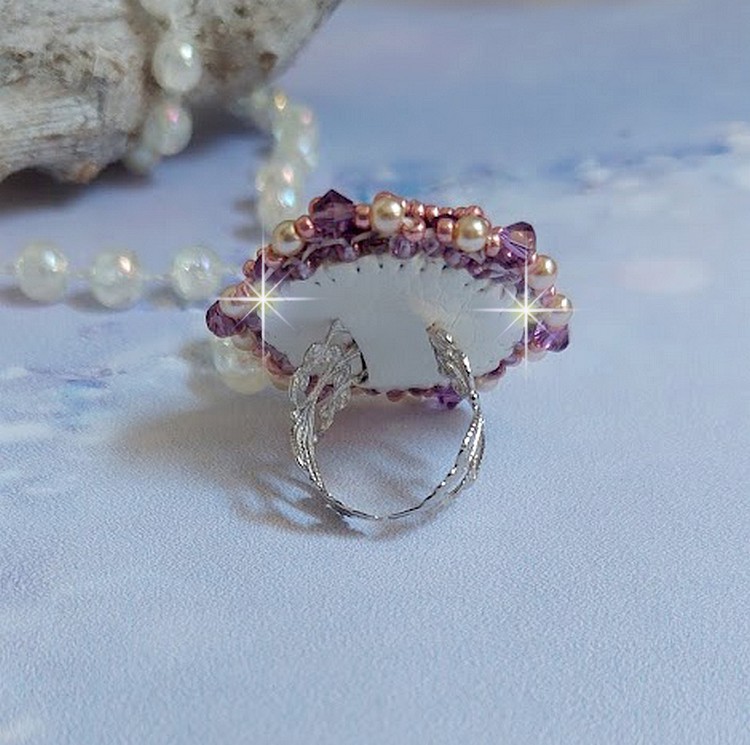 Bague Chinese Purple Stone brodée avec un cabochon rond en cristal Violet à laquelle s'ajoute une grande coupelle filigranée, facettes, perles rondes nacrées et rocailles sur un support bague Argentée