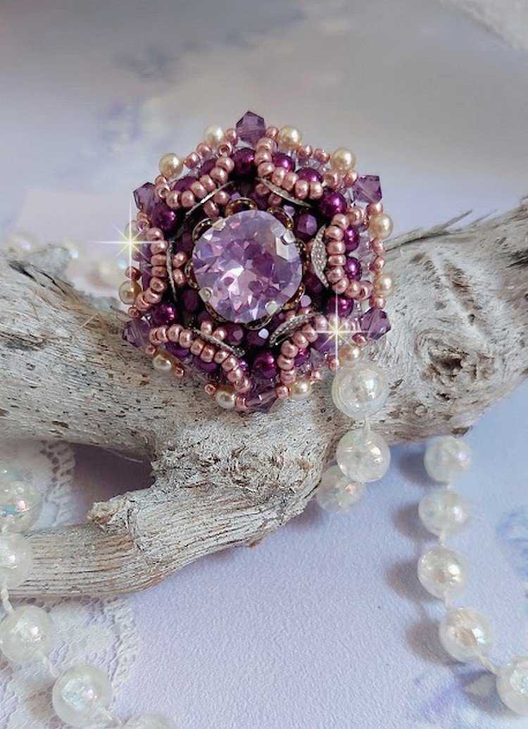 Bague Chinese Purple Stone brodée avec un cabochon rond en cristal Violet à laquelle s'ajoute une grande coupelle filigranée, facettes, perles rondes nacrées et rocailles sur un support bague Argentée