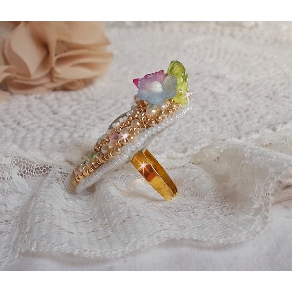 Bague Envol&eacute;e Fleurie brod&eacute;e avec un cabochon ovale Olivine en r&eacute;sine, orn&eacute;e de perles rondes nacr&eacute;es, des rocailles, fleurs Lucites, mini gouttes, chaton en Cristal et perles rondes aplaties.