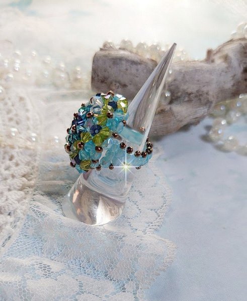 Bague Esp&eacute;rance mont&eacute;e avec toupies Aquamarine AB, Blue Zircon, Capri Blue, Olivine AB, Cristal avec des facettes entrelac&eacute;es avec des rocailles. Elle s&rsquo;adaptera parfaitement &agrave; votre doigt