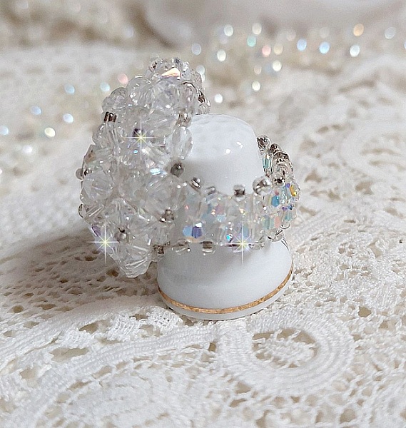  Bague Flocons mont&eacute;e avec des toupies en Cristal de Swarovski et des facettes en Verre de Boh&egrave;me o&ugrave; la couleur Blanche domine. Les perles s&rsquo;entrelacent avec les rocailles Argent&eacute;es comme des flocons 
