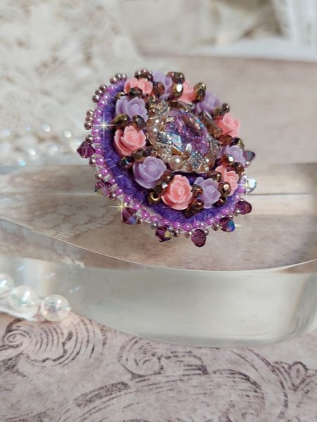 Bague Glace Purple brod&eacute;e avec un cabochon carr&eacute; Violet orn&eacute;e de cabochons roses en r&eacute;sine : Parme et Rose avec des toupies Am&eacute;thyste, facettes en Verre et rocailles. Mont&eacute;s sur une bague Dor&eacute;e