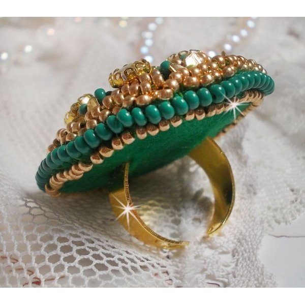 Bague Green Iris brod&eacute;e avec un cabochon Emeraude orn&eacute;e de chatons fleurs cristal sertis, rocailles Vert Opaque et Gold. Mont&eacute;s sur feutrine Verte et sur une bague plateau Dor&eacute;e, un style Contemporain
