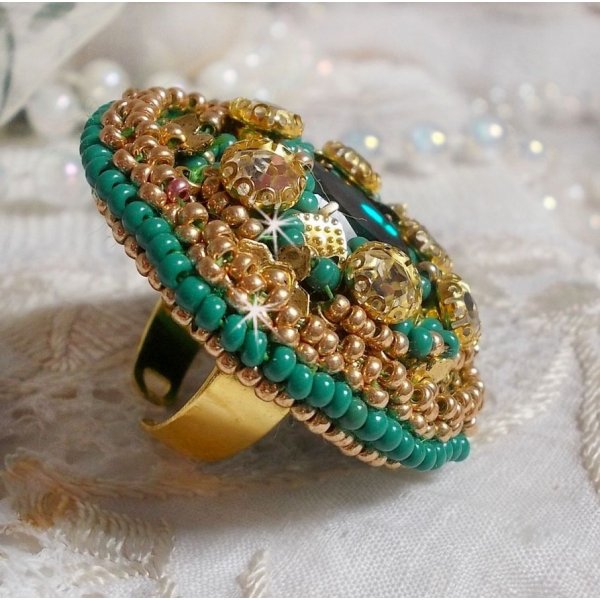 Bague Green Iris brod&eacute;e avec un cabochon Emeraude orn&eacute;e de chatons fleurs cristal sertis, rocailles Vert Opaque et Gold. Mont&eacute;s sur feutrine Verte et sur une bague plateau Dor&eacute;e, un style Contemporain