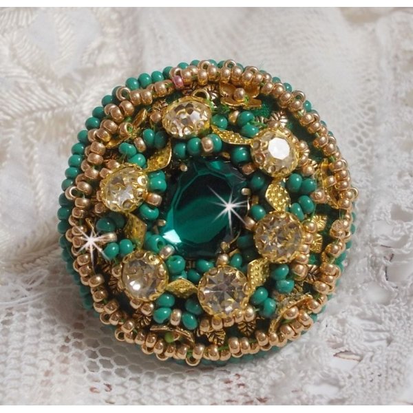 Bague Green Iris brod&eacute;e avec un cabochon Emeraude orn&eacute;e de chatons fleurs cristal sertis, rocailles Vert Opaque et Gold. Mont&eacute;s sur feutrine Verte et sur une bague plateau Dor&eacute;e, un style Contemporain
