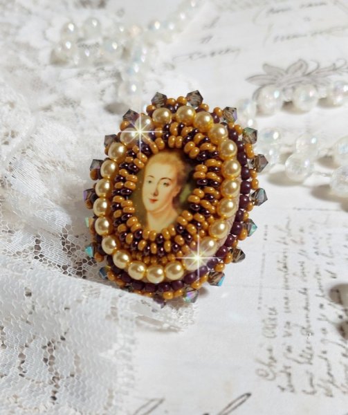 Bague Madame de Pompadour brod&eacute;e avec un cabochon repr&eacute;sentant une femme &agrave; laquelle s'ajoute des toupies, perles rondes nacr&eacute;es, rocailles aux couleurs Jaune et Marron sur bague Bronze en laiton