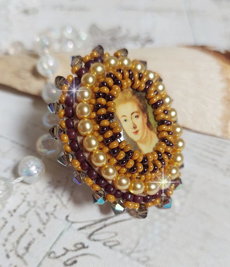 Bague Madame de Pompadour brodée avec un cabochon représentant une femme à laquelle s'ajoute des toupies, perles rondes nacrées, rocailles aux couleurs Jaune et Marron sur bague Bronze en laiton