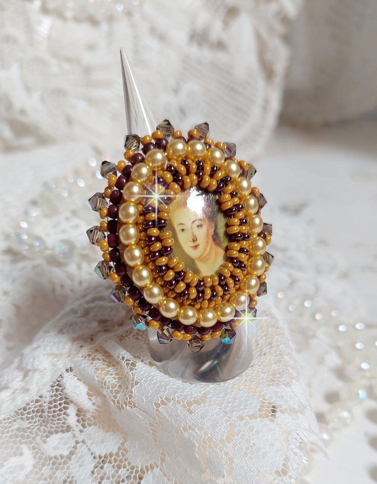 Bague Madame de Pompadour brodée avec un cabochon représentant une femme à laquelle s'ajoute des toupies, perles rondes nacrées, rocailles aux couleurs Jaune et Marron sur bague Bronze en laiton