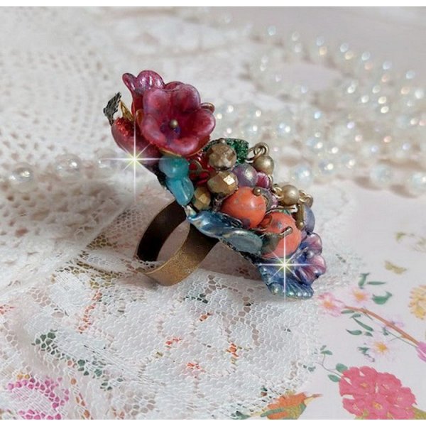 Bague Onia pour une composition florale créée avec des cristaux, fleurs : perles, clochettes, pensées, gouttes Druzy,  pierre de gemme : le Corail, perles cloisonnées et bague ovale en Laiton
