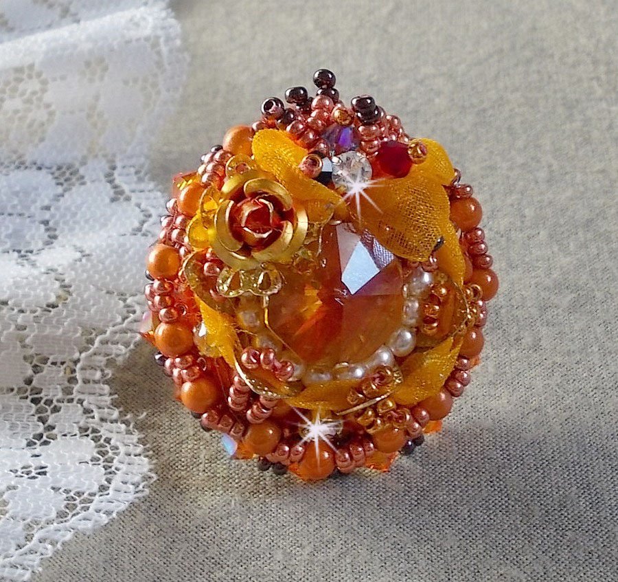 Bague Les Rêves d'Acapulco brodée avec un cabochon octogonale serti à laquelle s'ajoute perles rondes nacrées, ruban organza, toupies et rocailles sur bague en laiton Bronze pour un style ethnique