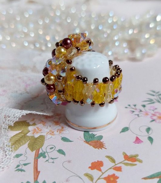 Bague Soleil mont&eacute;e avec des toupies en Cristal de Swarovski aux couleurs Topaze, Gold et Marron &agrave; laquelle s&rsquo;ajoute des facettes en Verre de Boh&egrave;me. Les perles s&rsquo;entrelacent avec les rocailles Dor&eacute;es